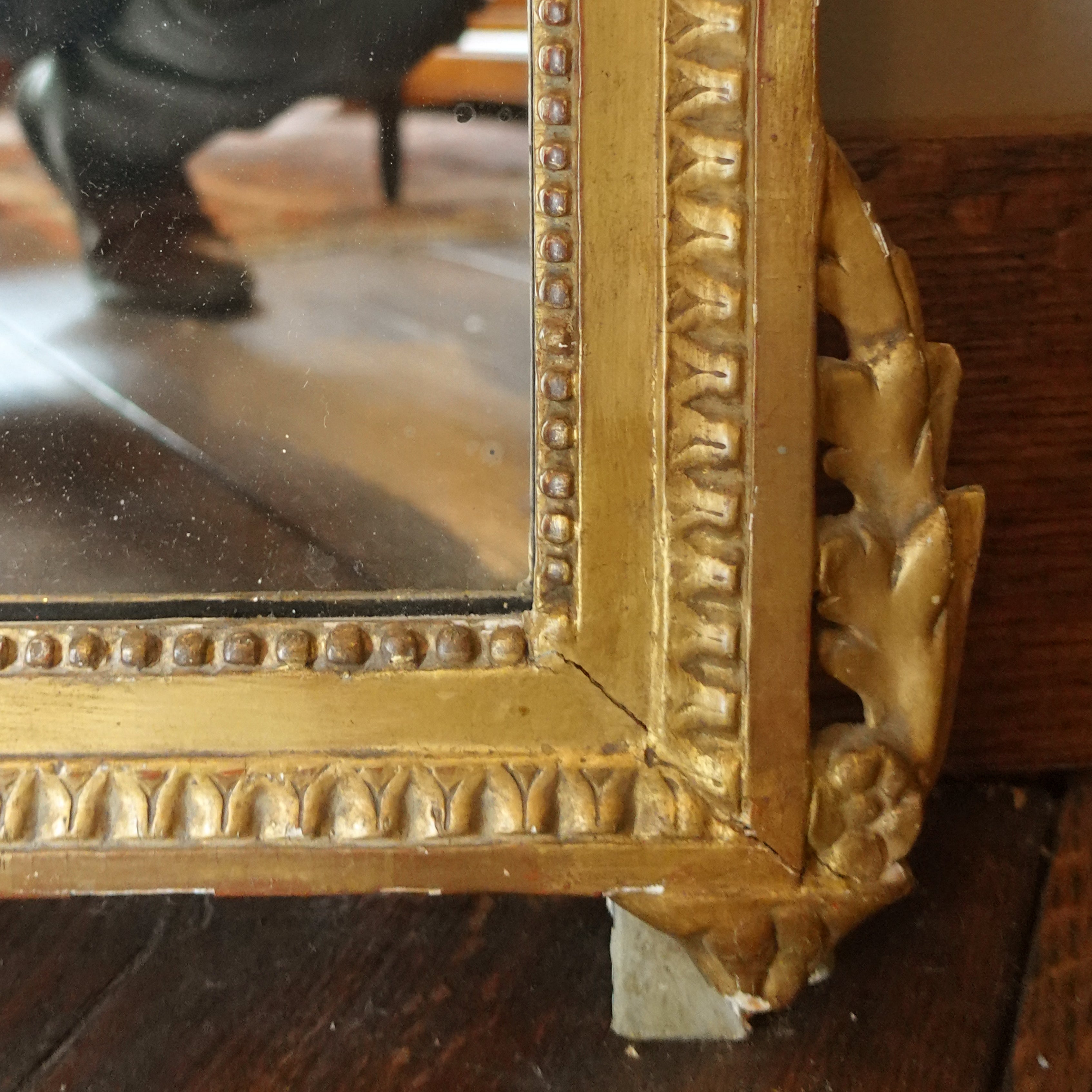 Detail of hand-carved Neo-Classical floral motifs and scrollwork on antique Swedish giltwood frame