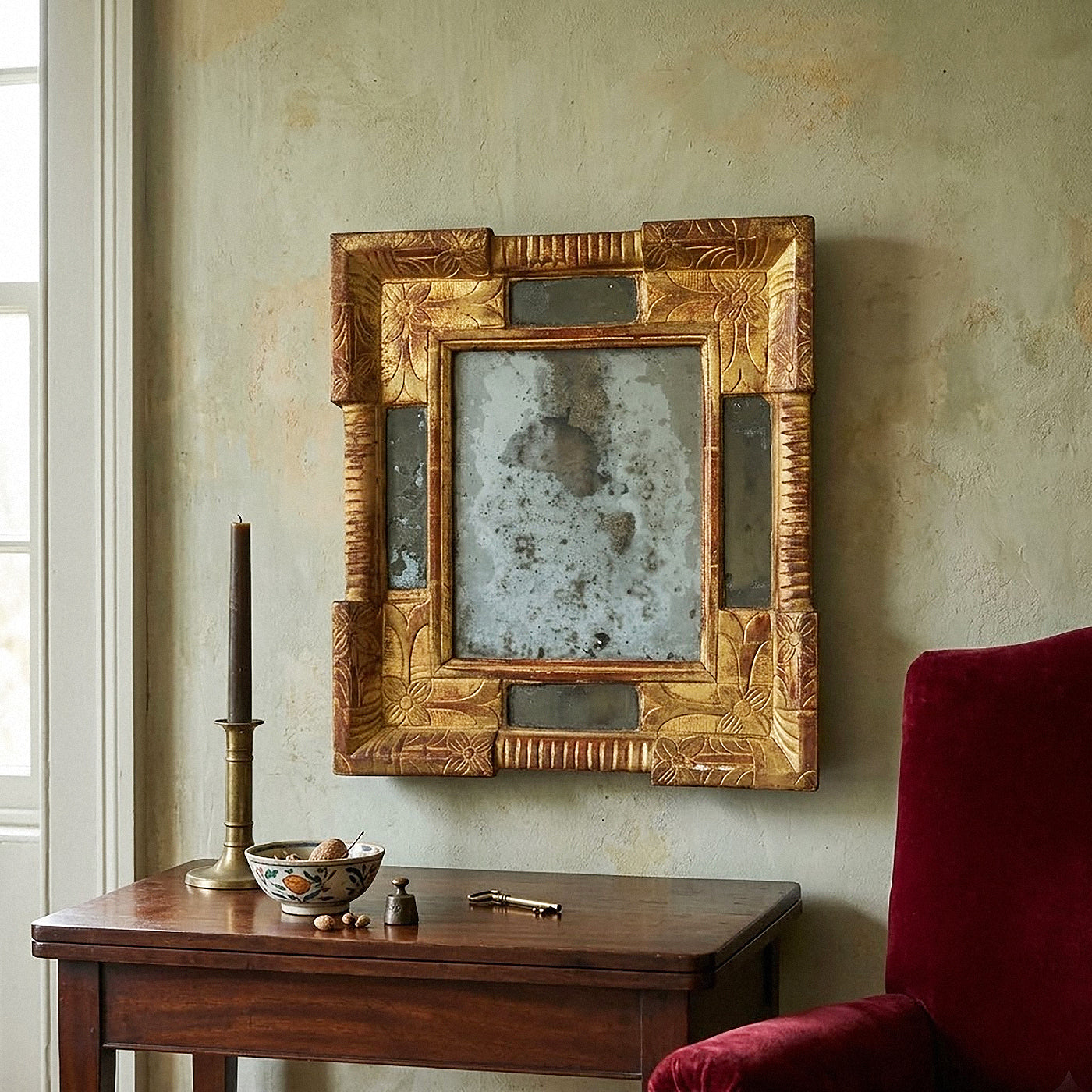 Authentic 17th-century Italian Baroque giltwood cassetta mirror featuring hand-carved floral motifs, red bole patina, and heavily oxidized mercury glass from Le Historique.