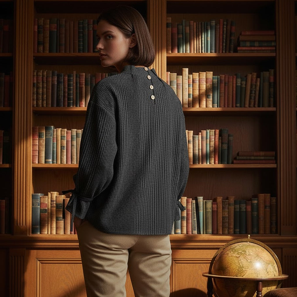 Rear view of a woman wearing a romantic heritage linen blouse with back buttons, set against a backdrop of antique books.