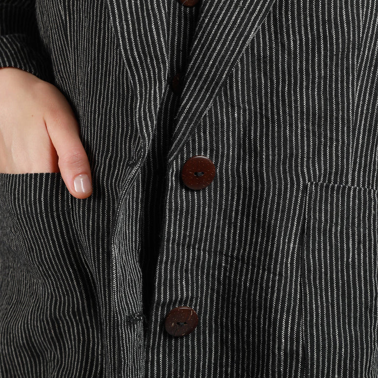 Close-up of high-quality French seams, functional side pockets, and OEKO-TEX certified pinstripe linen fabric.