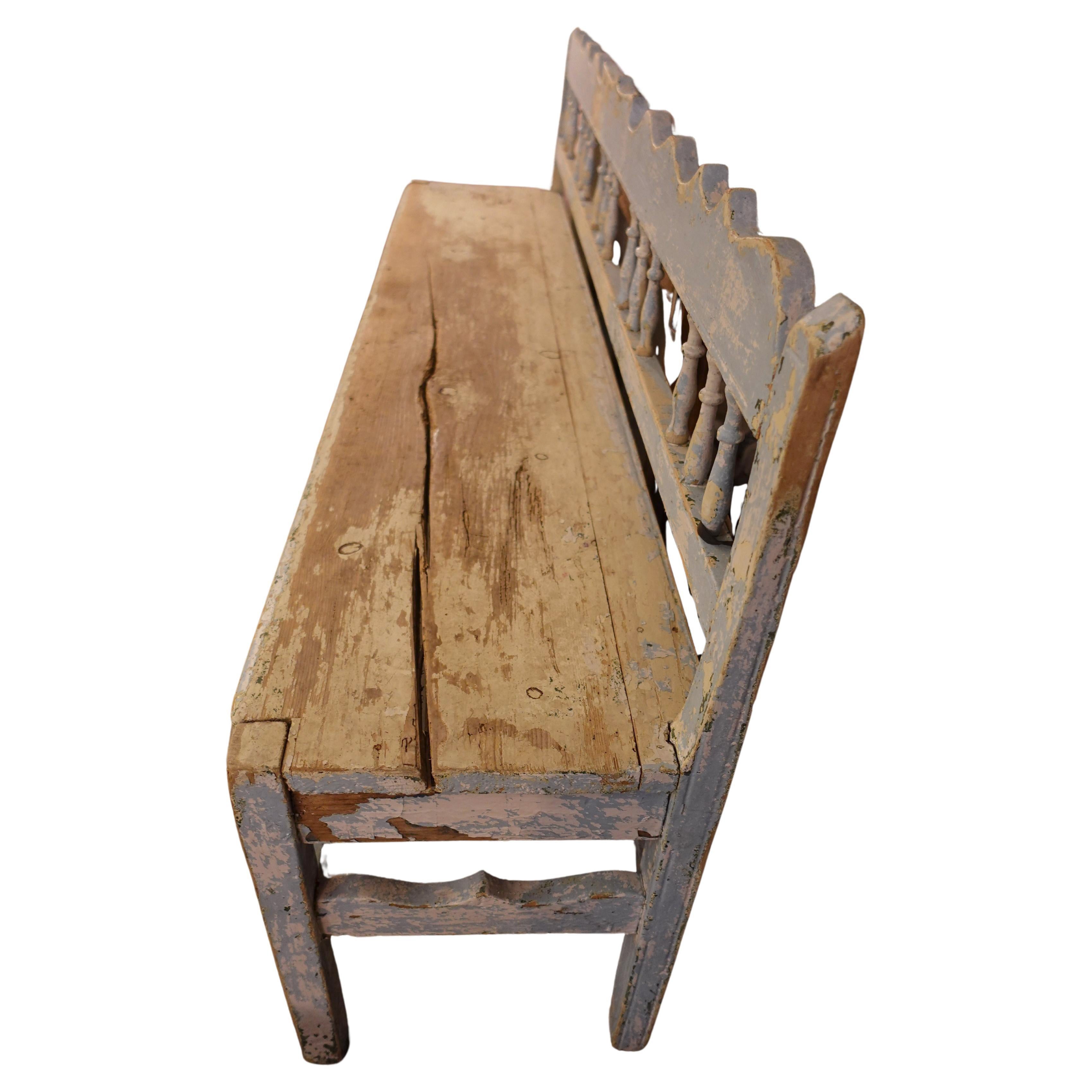 Profile of a petite 19th-century Gustavian bench highlighting the slender Neoclassical frame and authentic weathered texture for an old-world interior.