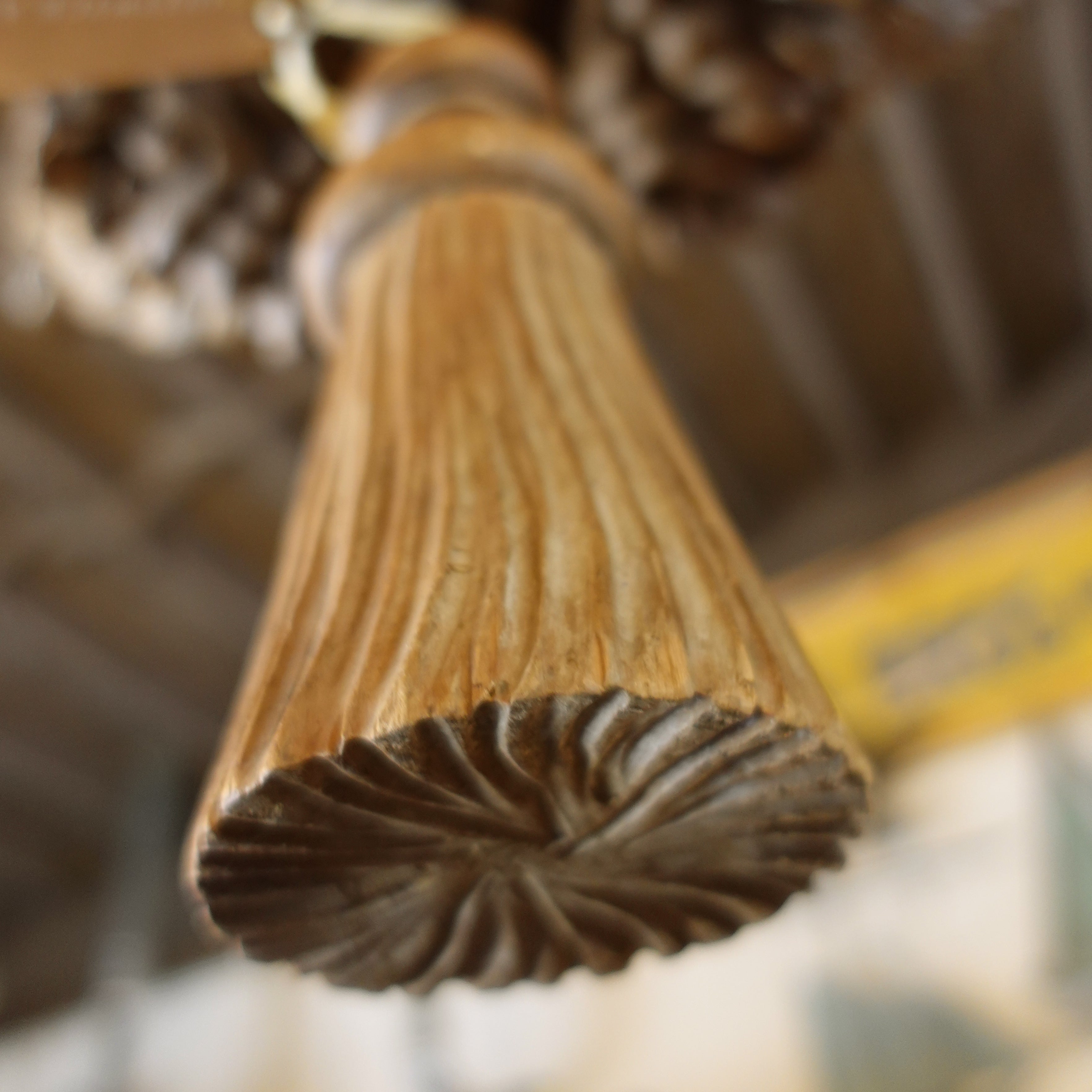Close-up of a wooden chandelier tassel with a blurred background
