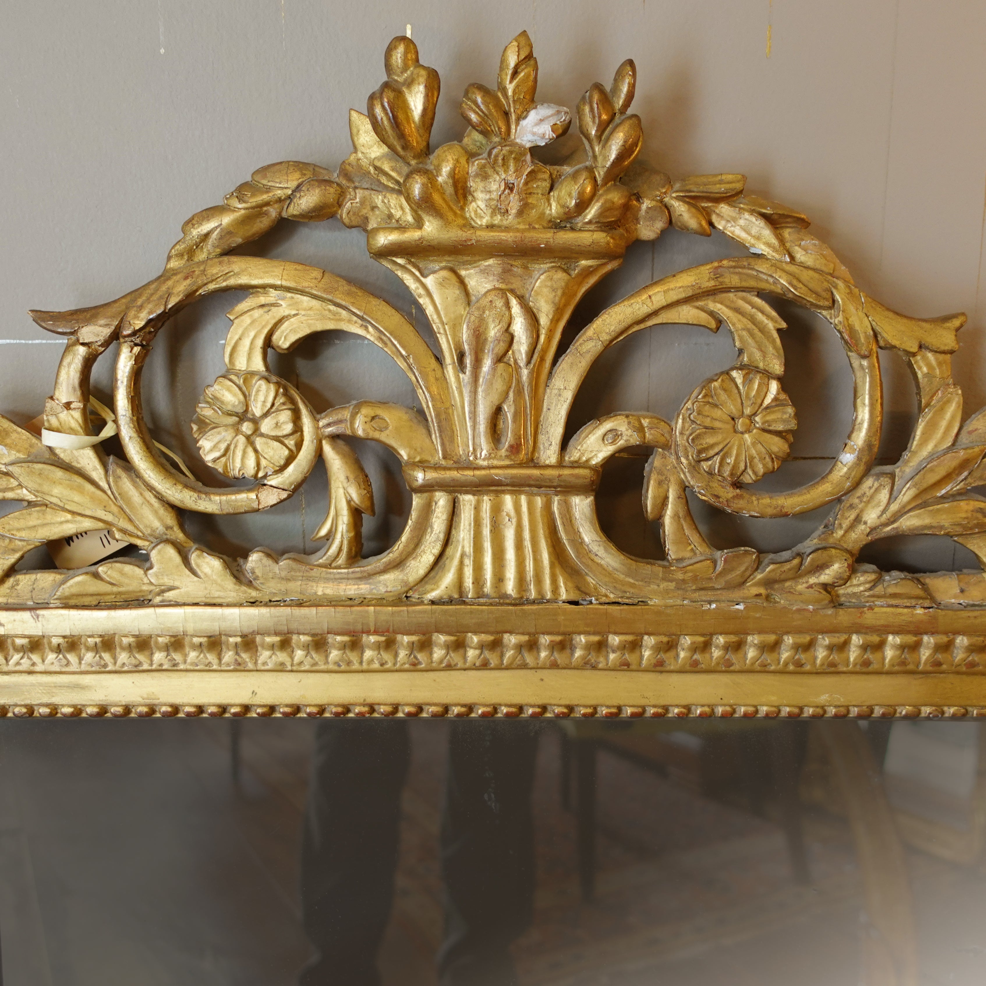 Detail of hand-carved Neo-Classical floral motifs and scrollwork on antique Swedish giltwood frame