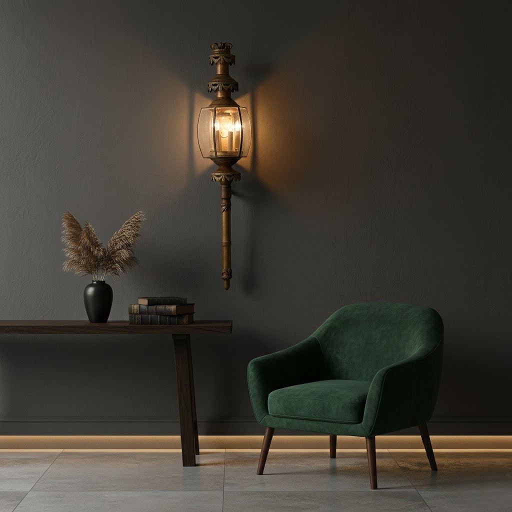 Dark green armchair in a room with a wall sconce and decorative items.