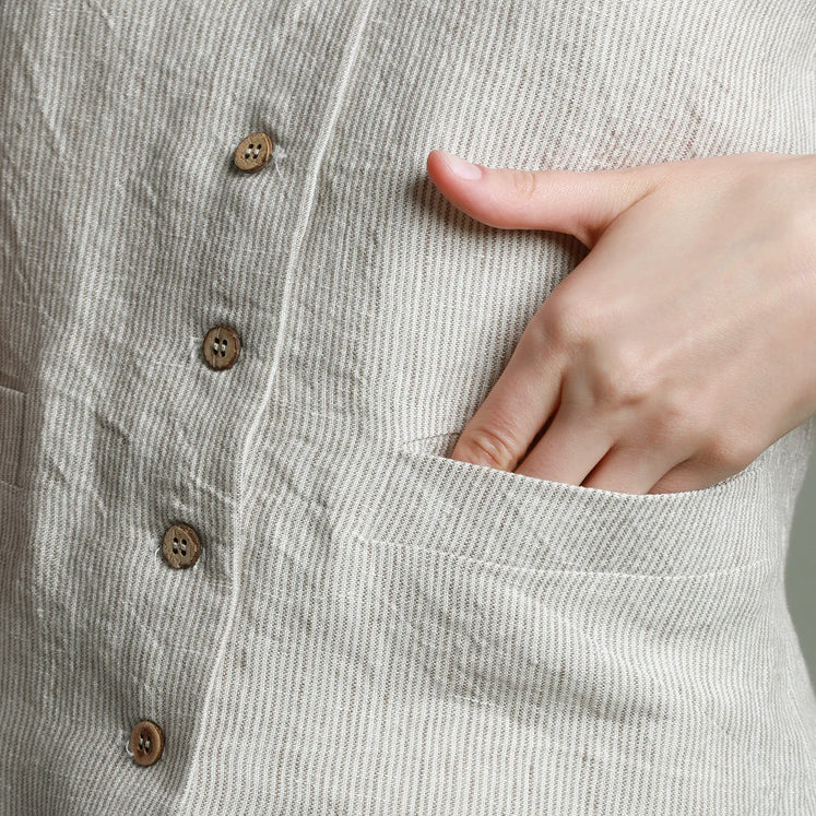 Macro detail of high-quality European linen fabric with beige pinstripes, highlighting functional side pockets and premium French seam construction.