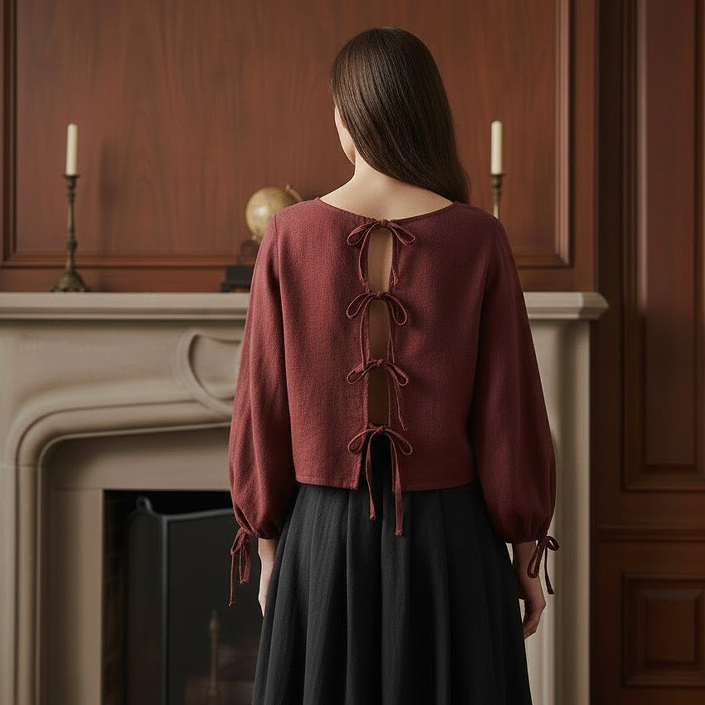 Back view of a handmade wine linen shirt revealing an open back design with romantic tie closures and high-quality French hidden seams.