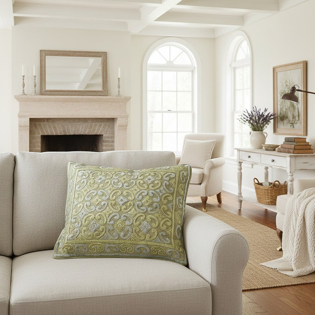 Living room with a beige sofa, decorative pillow, and a fireplace.