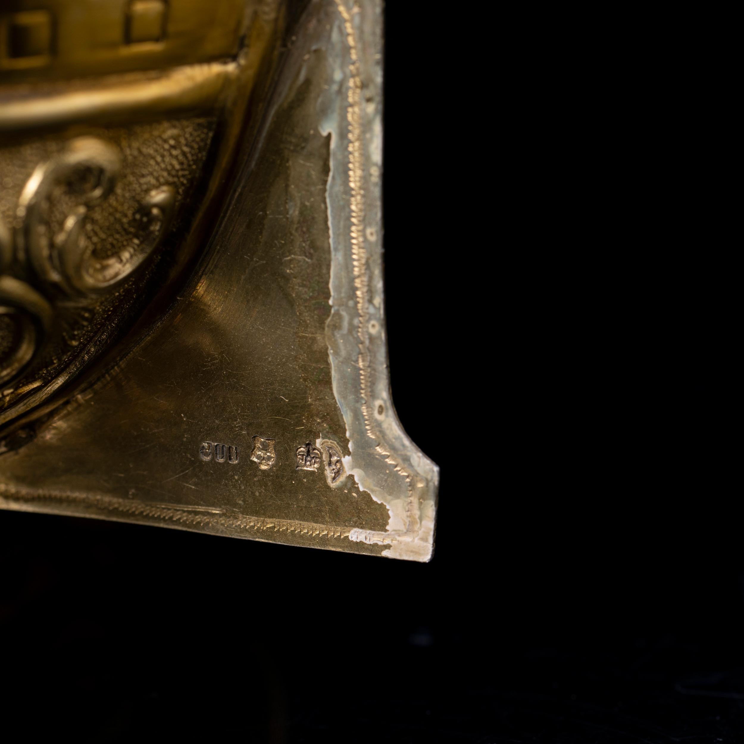 Close-up of a silver nef with engraved details and German hallmarks on a black background