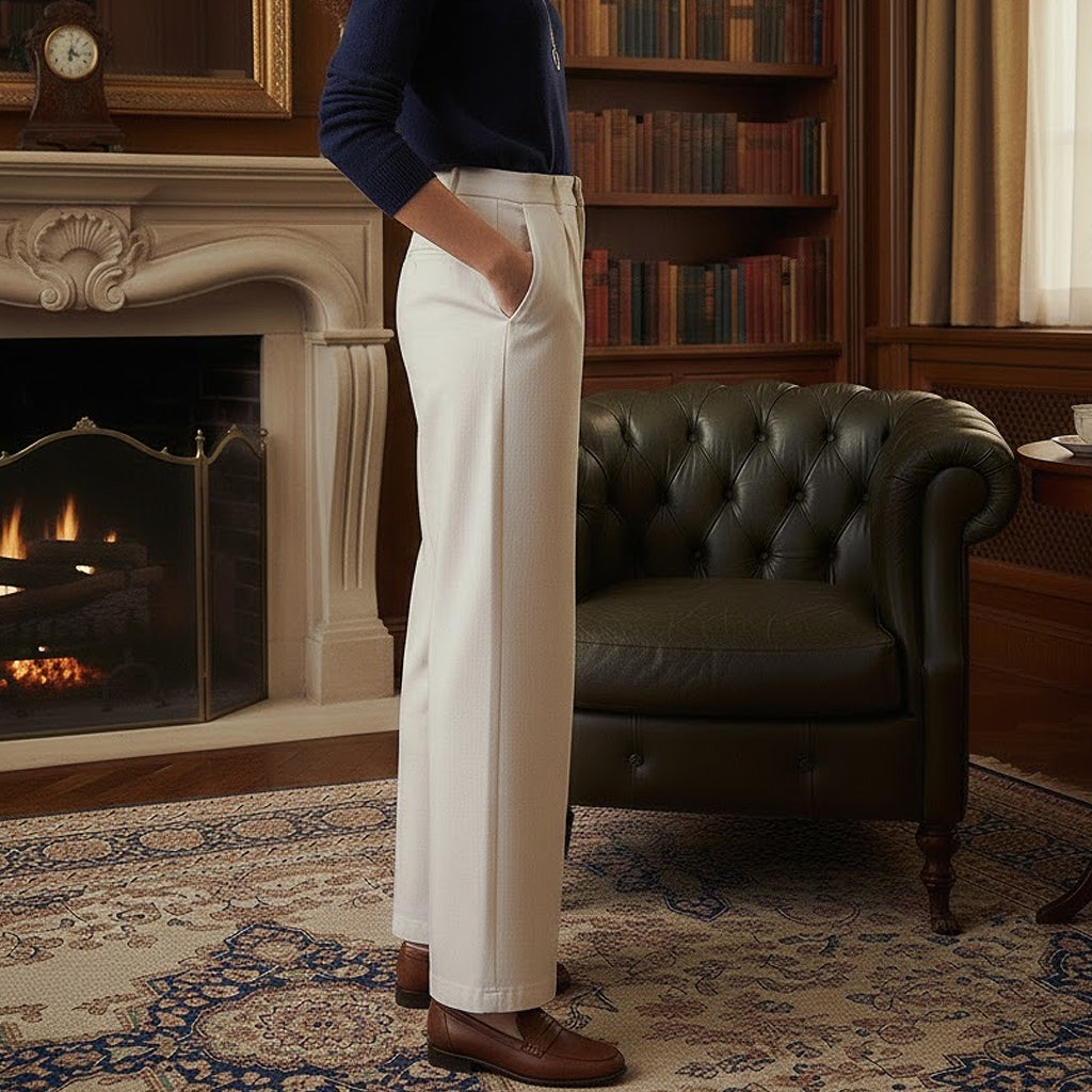 Side profile of well-constructed heritage cotton trousers in cream, highlighting the smooth drape, deep side pockets, and clean architectural lines of the wide-leg silhouette.