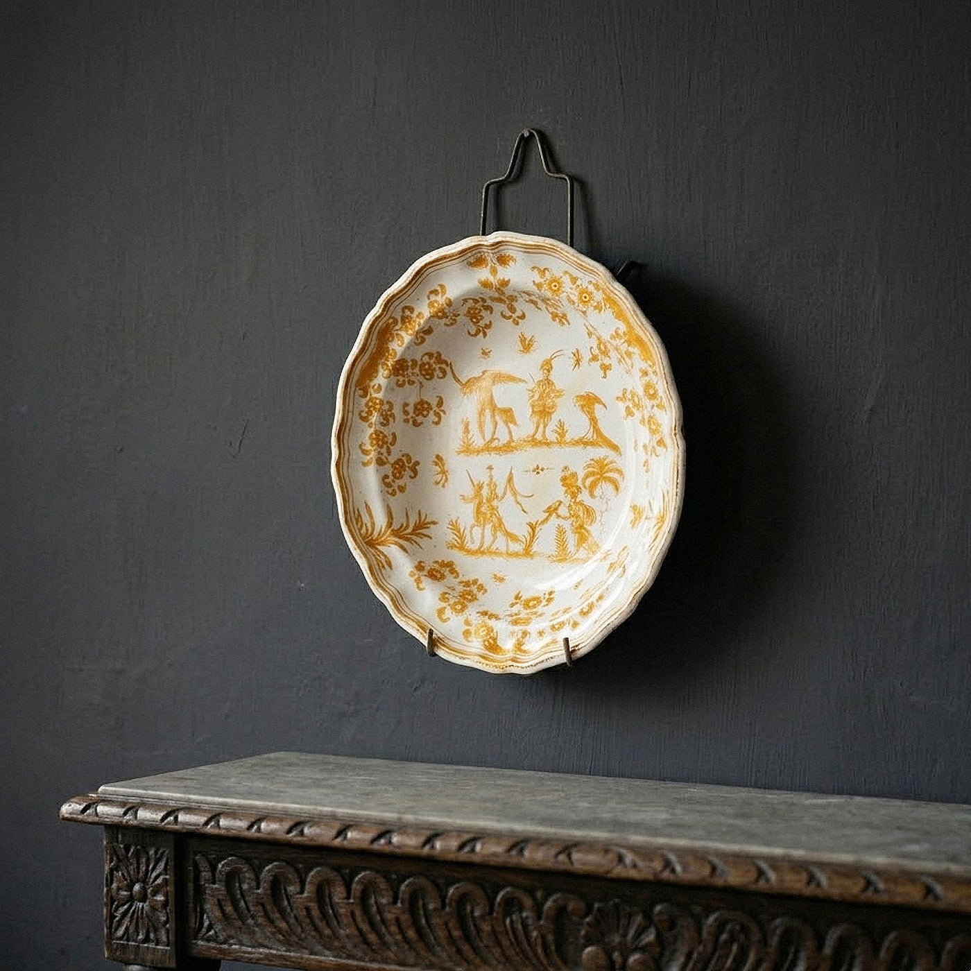 Rare 18th-century French Moustiers Faience earthenware deep plate featuring yellow monochrome ochre grotesque decoration in the style of Jacques Callot, curated by Le Historique.