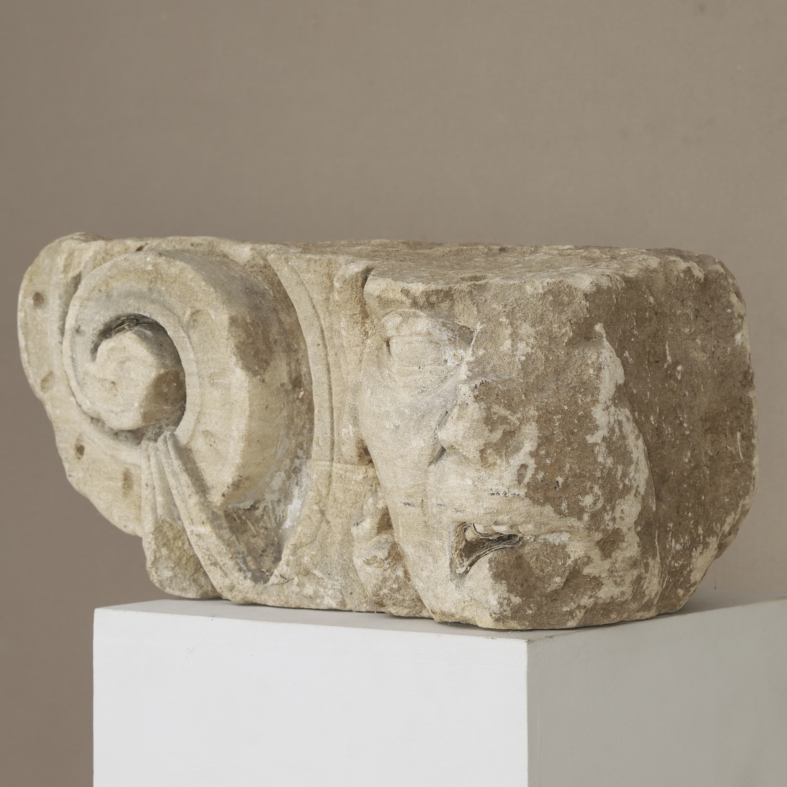 Rare interior modillion carved in the French Renaissance style from Pierre de Caen. This architectural fragment from Rouen (c. 1515–1550) combines a detailed Ionic volute with a chimera grotesque. A curated piece for luxury interiors.